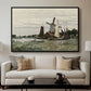 Windmill at Zaandam, 1871 by Claude Monet displayed in a black floater framed canvas above a sofa in a clean living room.