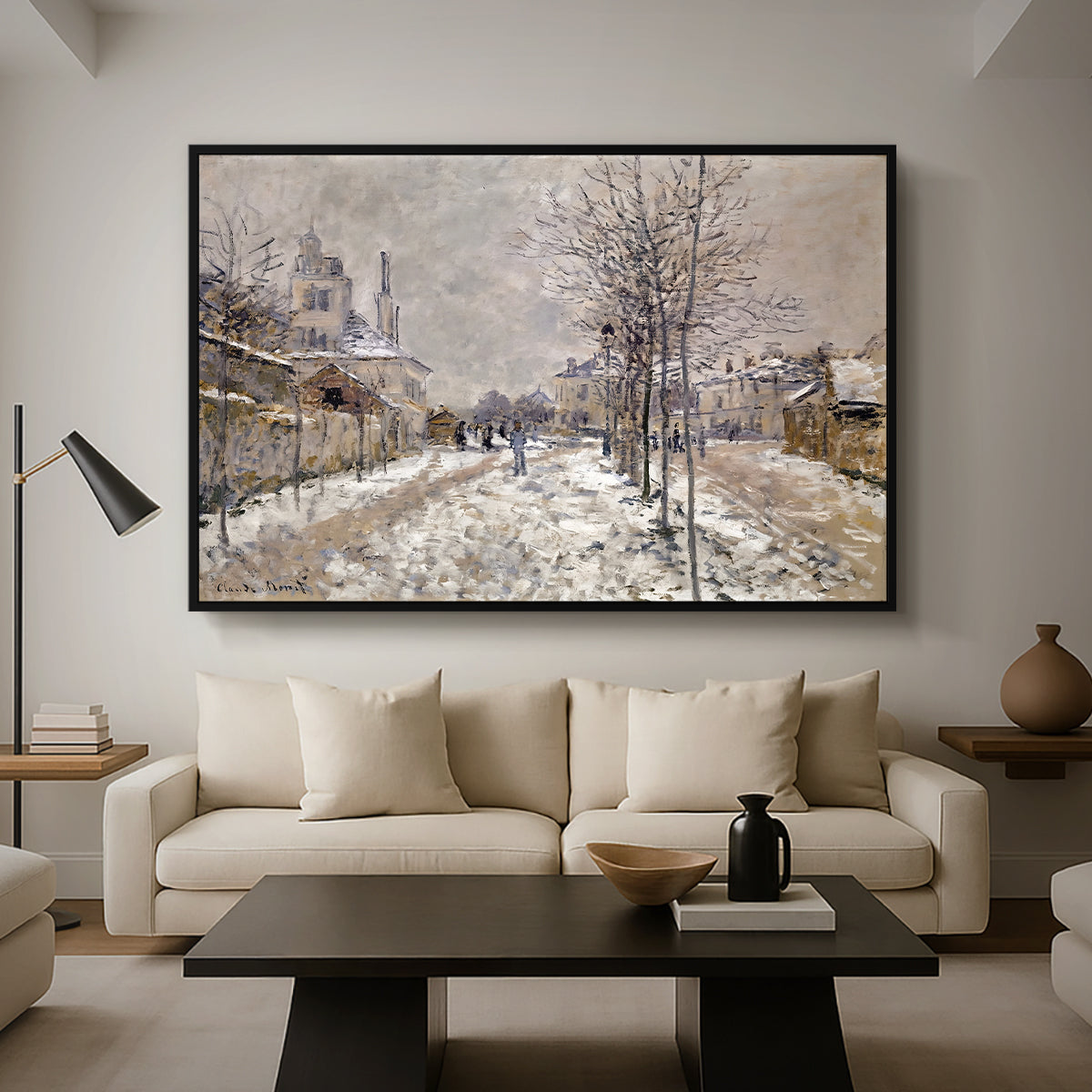 The Boulevard de Pontoise at Argenteuil, Snow Effect, 1875 by Claude Monet as a black floater framed canvas featuring a snow-covered street lined with trees and buildings under winter sky, displayed above a sofa in a modern living room.