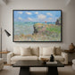 The Cliff Walk at Pourville, 1882 by Claude Monet as a black floater framed canvas featuring figures walking along coastal cliff path overlooking ocean and sky, displayed above a sofa in a modern living room.