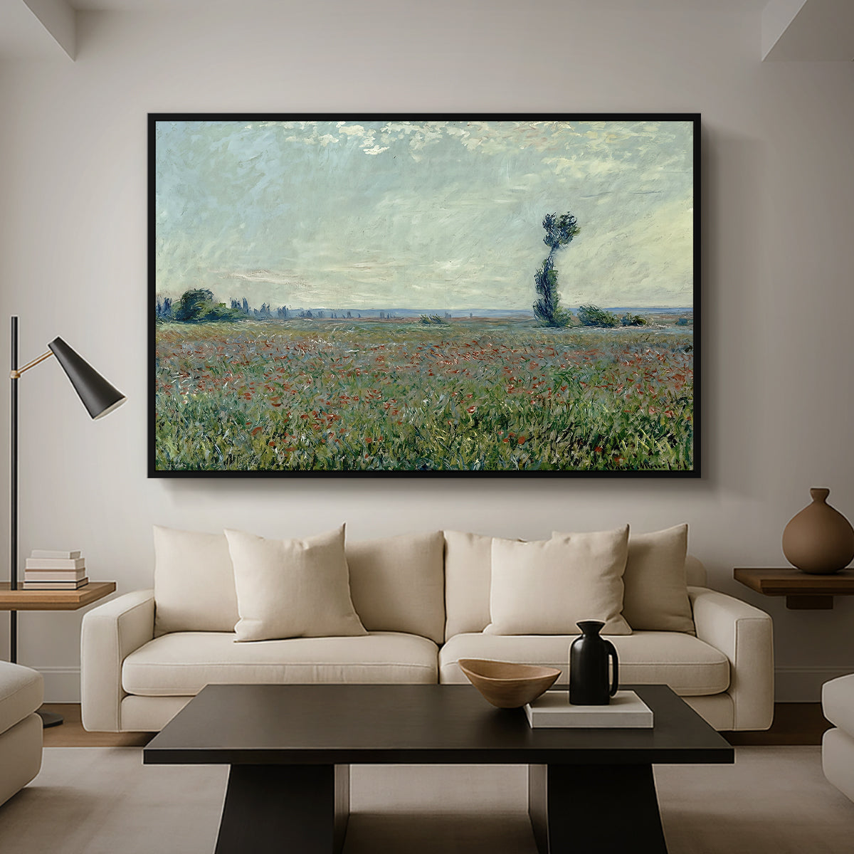 Poppy Field, 1881 by Claude Monet as a black floater framed canvas featuring a wide field of red poppies stretching across countryside under open sky, displayed above a sofa in a modern living room.