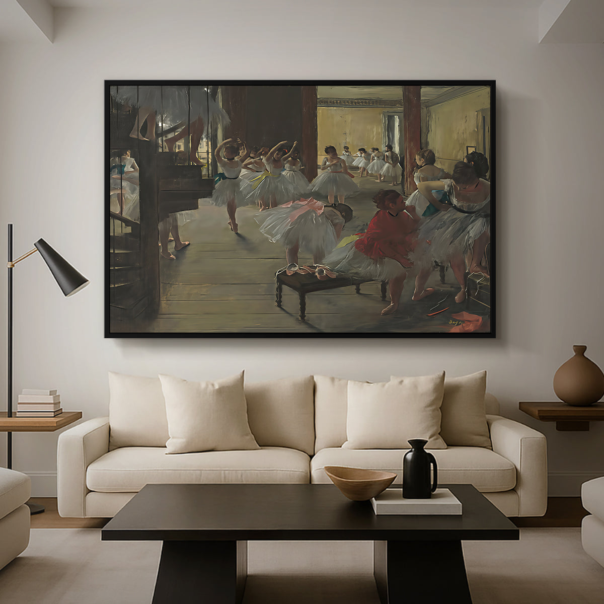 The Dance Class, c. 1873 by Edgar Degas as a black floater framed canvas featuring ballerinas practicing in studio with instructor observing nearby, displayed above a sofa in a modern living room.