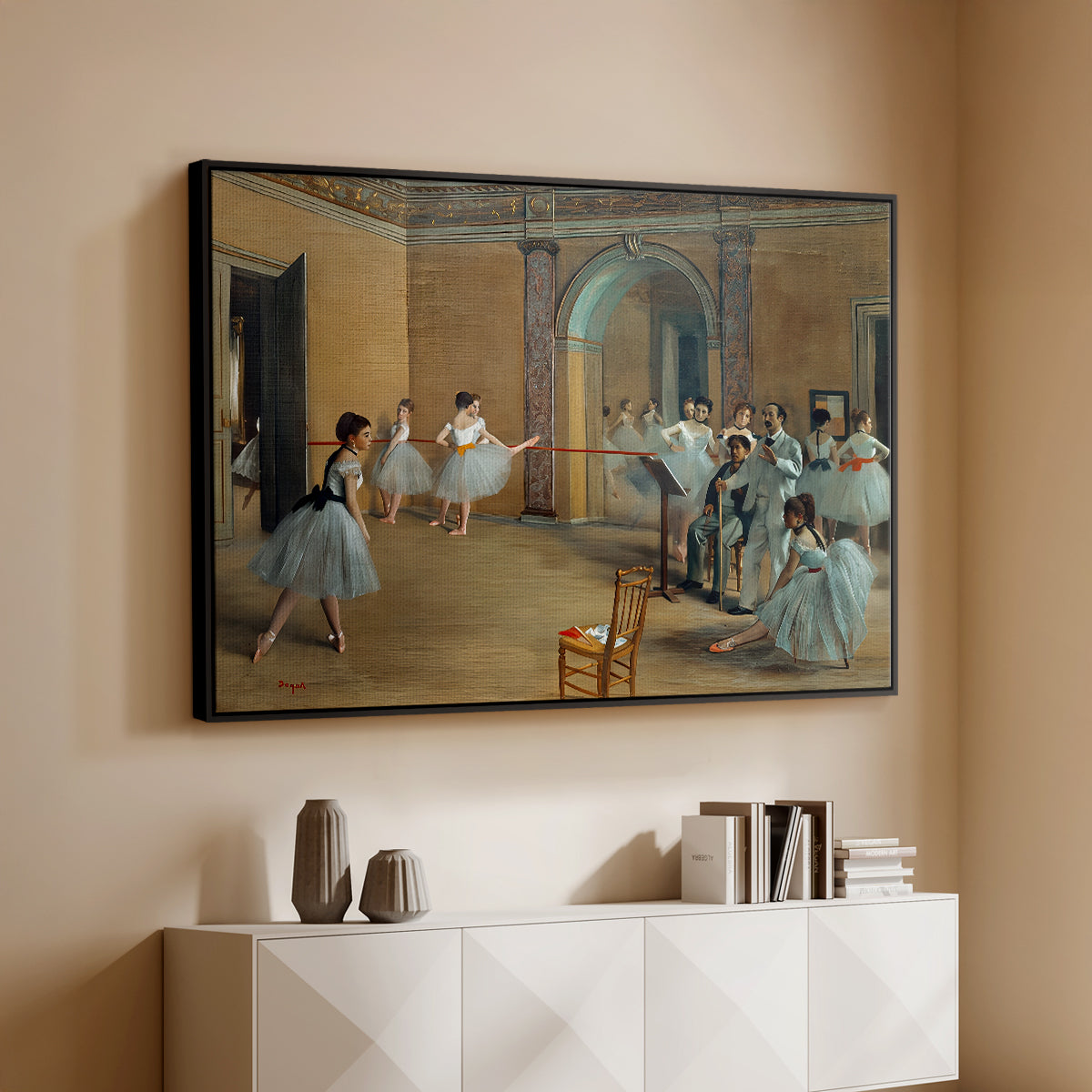 Black floater framed canvas of The Dance Foyer at the Opera on the Rue Le Peletier, 1872 by Edgar Degas, featuring an interior scene of dancers waiting and stretching in large studio above a console cabinet in a minimalist entryway.