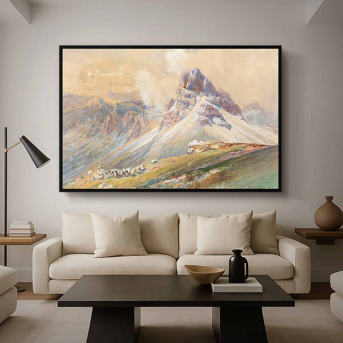 From the Dolomites, 1904 by Edward Theodore Compton as a black floater framed canvas featuring dramatic Dolomite mountain peaks rising above rugged terrain, displayed above a sofa in a modern living room.