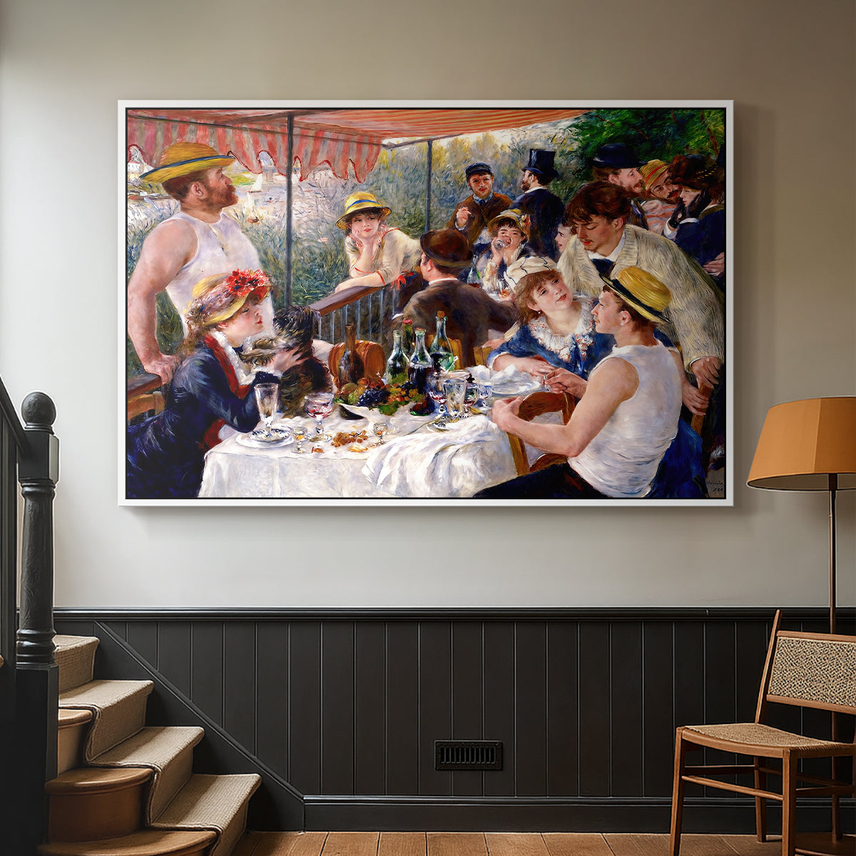 White floater framed canvas featuring a social dining scene with figures seated around table on riverside terrace, displayed in a hallway near a staircase.