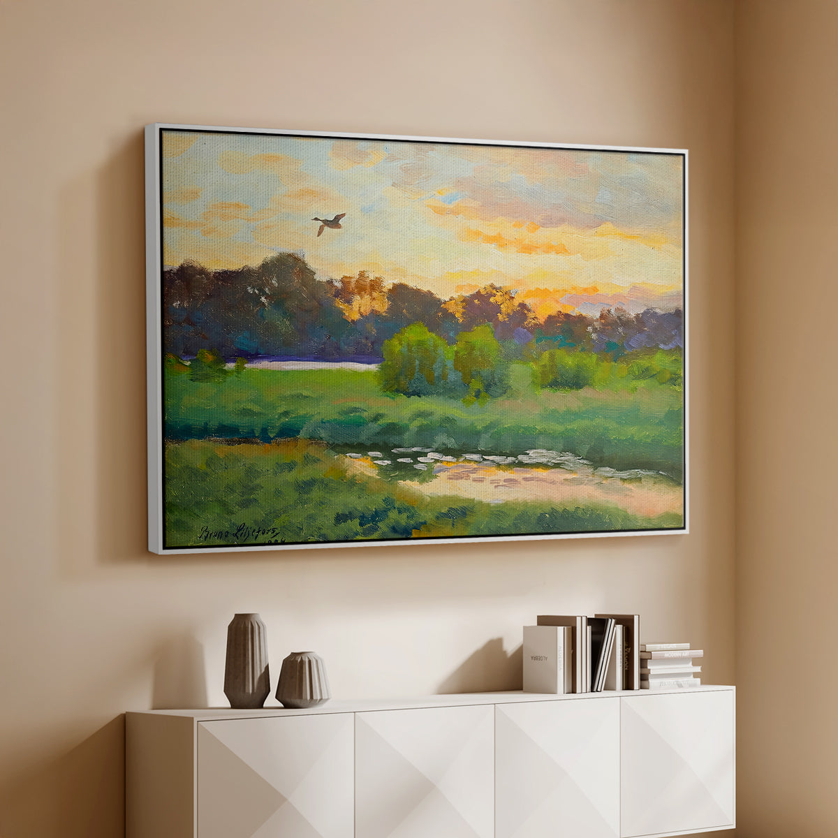 White floater framed canvas of Flying Duck at Sunset, 1924 by Bruno Liljefors, featuring a lone duck soaring over a glowing marshland above a console cabinet in a minimalist entryway.