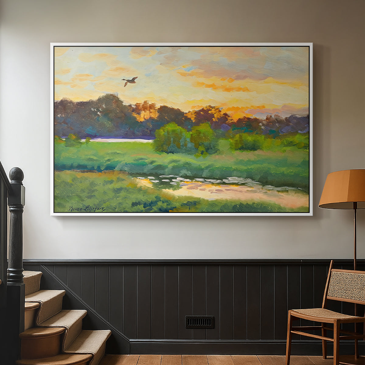 White floater framed canvas featuring a lone duck flying over a marsh at golden hour, displayed in a hallway near a staircase.