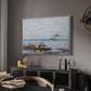 Greylag Geese (Grågäss), 1922 by Bruno Liljefors in a white floater framed canvas featuring a realistic wildlife scene of geese in calm outdoor environment, displayed above a desk in a dark home office interior.