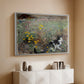 White floater framed canvas of Cat on a Flowery Meadow, 1887 by Bruno Liljefors, featuring a small cat resting among colorful flowers in grassy field above a console cabinet in a minimalist entryway.