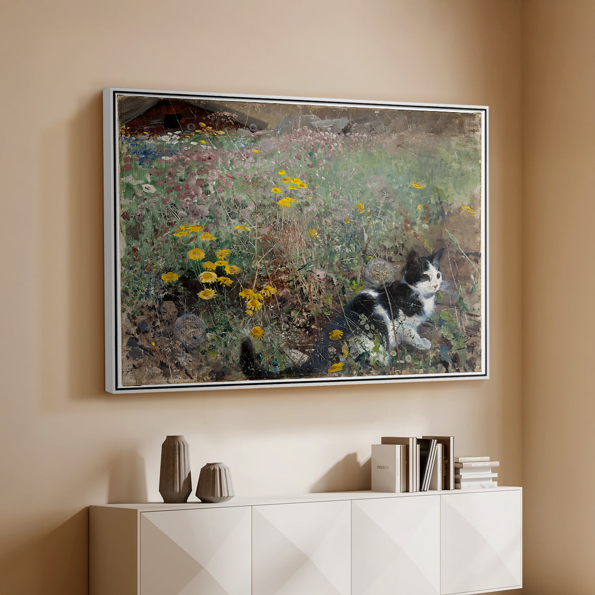 White floater framed canvas of Cat on a Flowery Meadow, 1887 by Bruno Liljefors, featuring a small cat resting among colorful flowers in grassy field above a console cabinet in a minimalist entryway.