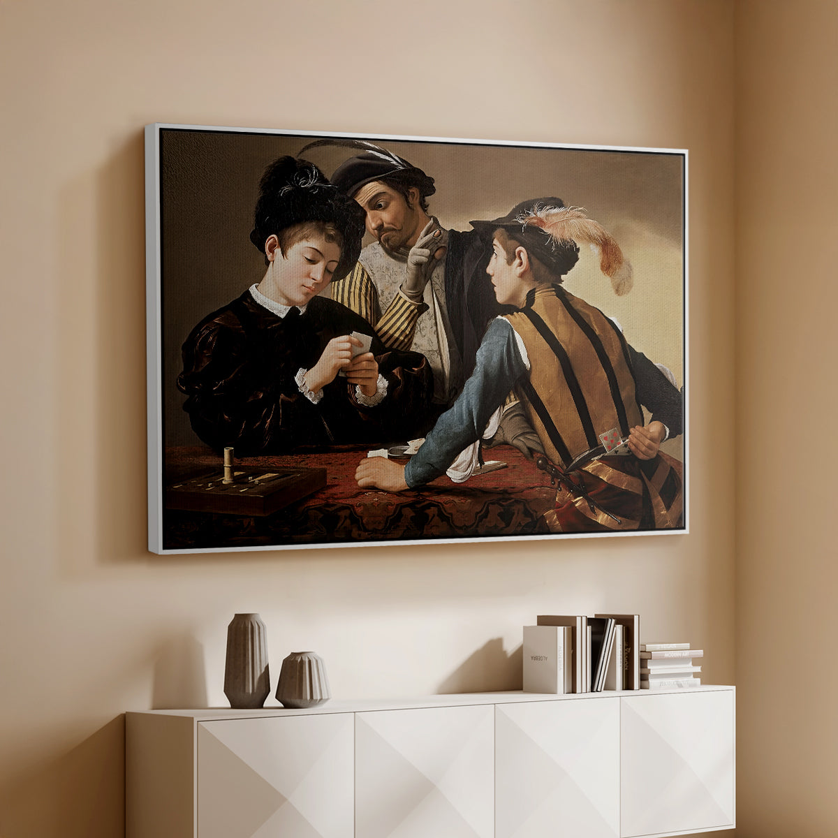 White floater framed canvas of The Cardsharps, c. 1594 by Caravaggio, featuring a genre scene of card game with deception and hidden accomplice above a console cabinet in a minimalist entryway.