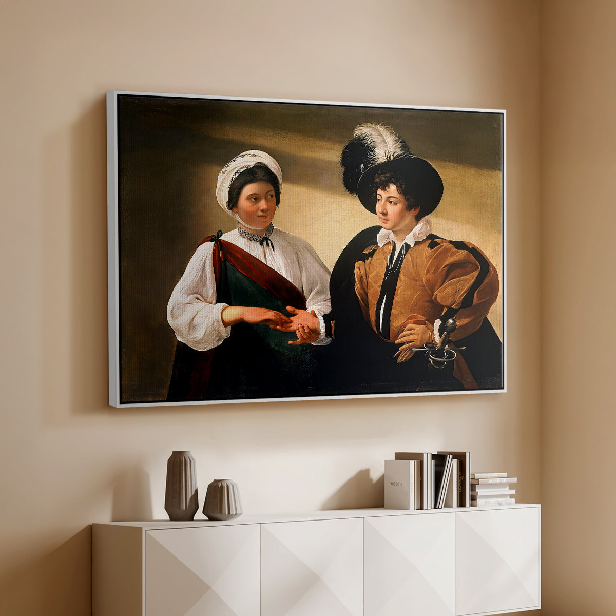 White floater framed canvas of The Fortune Teller (Louvre Version), c. 1595 by Caravaggio, featuring a fortune teller examining hand of man as she slyly removes his ring above a console cabinet in a minimalist entryway.