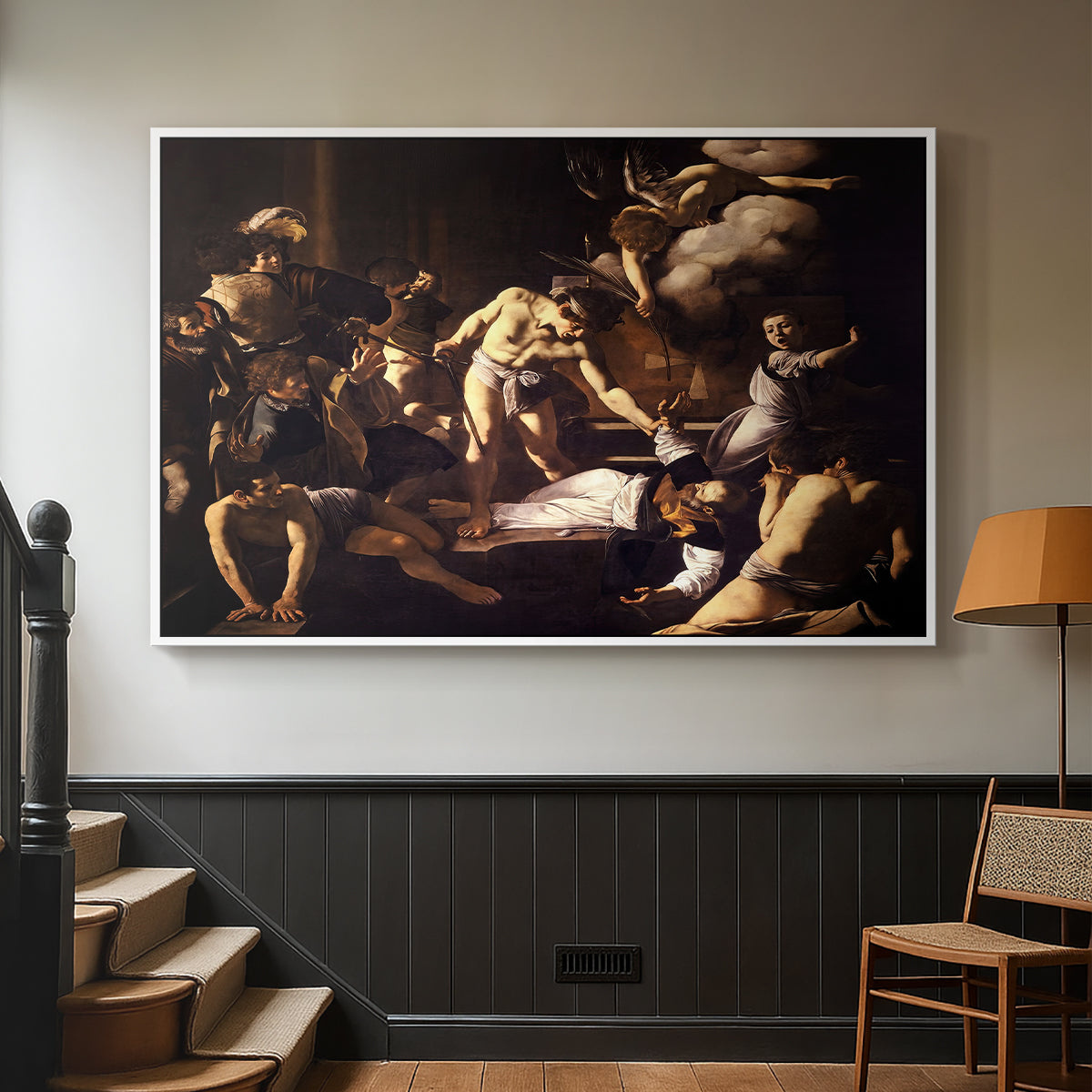 White floater framed canvas featuring a Baroque composition of movement and emotion during martyrdom, displayed in a hallway near a staircase.