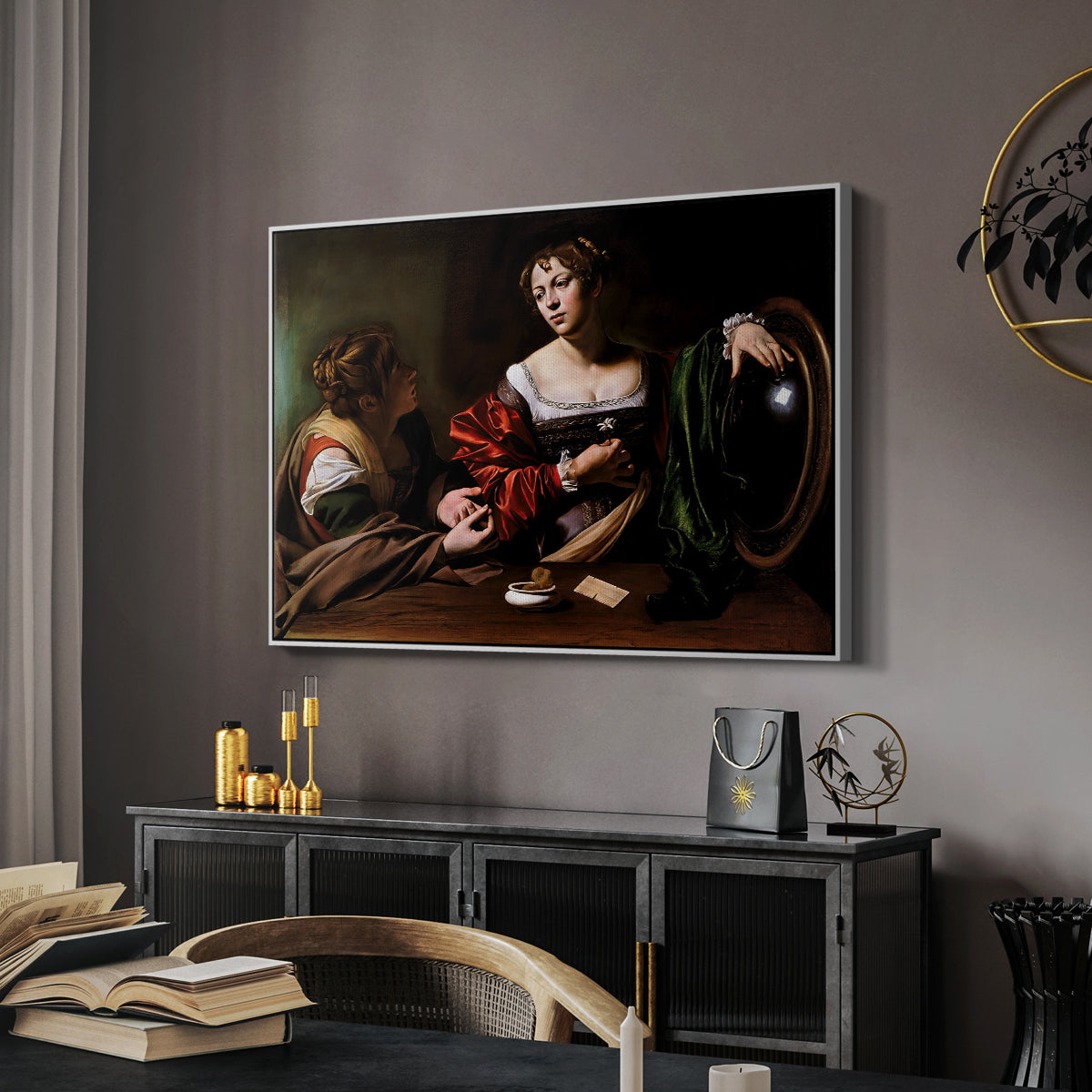 Martha and Mary Magdalene, c. 1598 by Caravaggio in a white floater framed canvas featuring an intimate interaction between two women with mirror and objects, displayed above a desk in a dark home office interior.