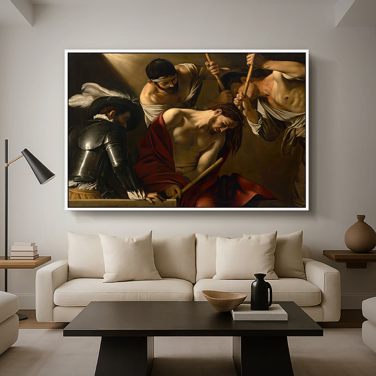 The Crowning with Thorns (Vienna Version), c. 1602-1604 by Caravaggio as a white floater framed canvas featuring Christ surrounded by men pressing crown of thorns onto his head, displayed above a sofa in a modern living room.