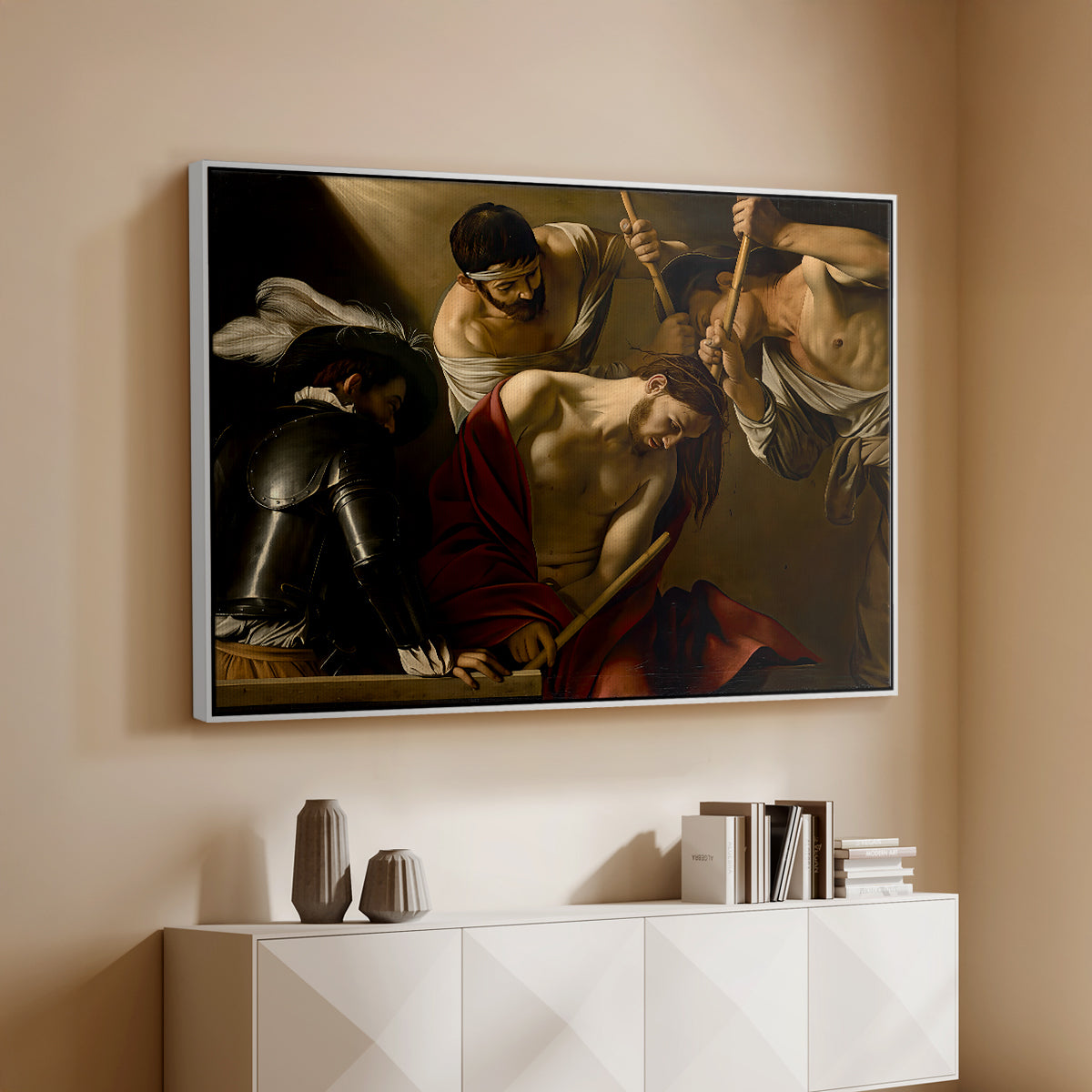 White floater framed canvas of The Crowning with Thorns (Vienna Version), c. 1602-1604 by Caravaggio, featuring a biblical scene of Christ being mocked and crowned with thorns above a console cabinet in a minimalist entryway.