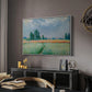 The Wheat Field (Champ de Blé), 1881 by Claude Monet in a white floater framed canvas featuring an agricultural landscape with tall wheat and distant horizon, displayed above a desk in a dark home office interior.