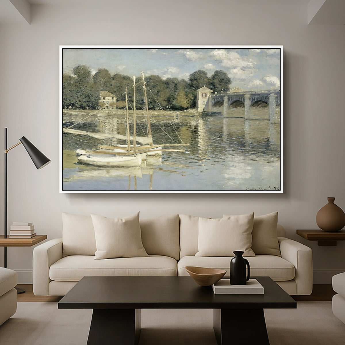 The Bridge at Argenteuil, 1874 by Claude Monet as a white floater framed canvas featuring a bridge spanning river with sailboats and reflections in water, displayed above a sofa in a modern living room.