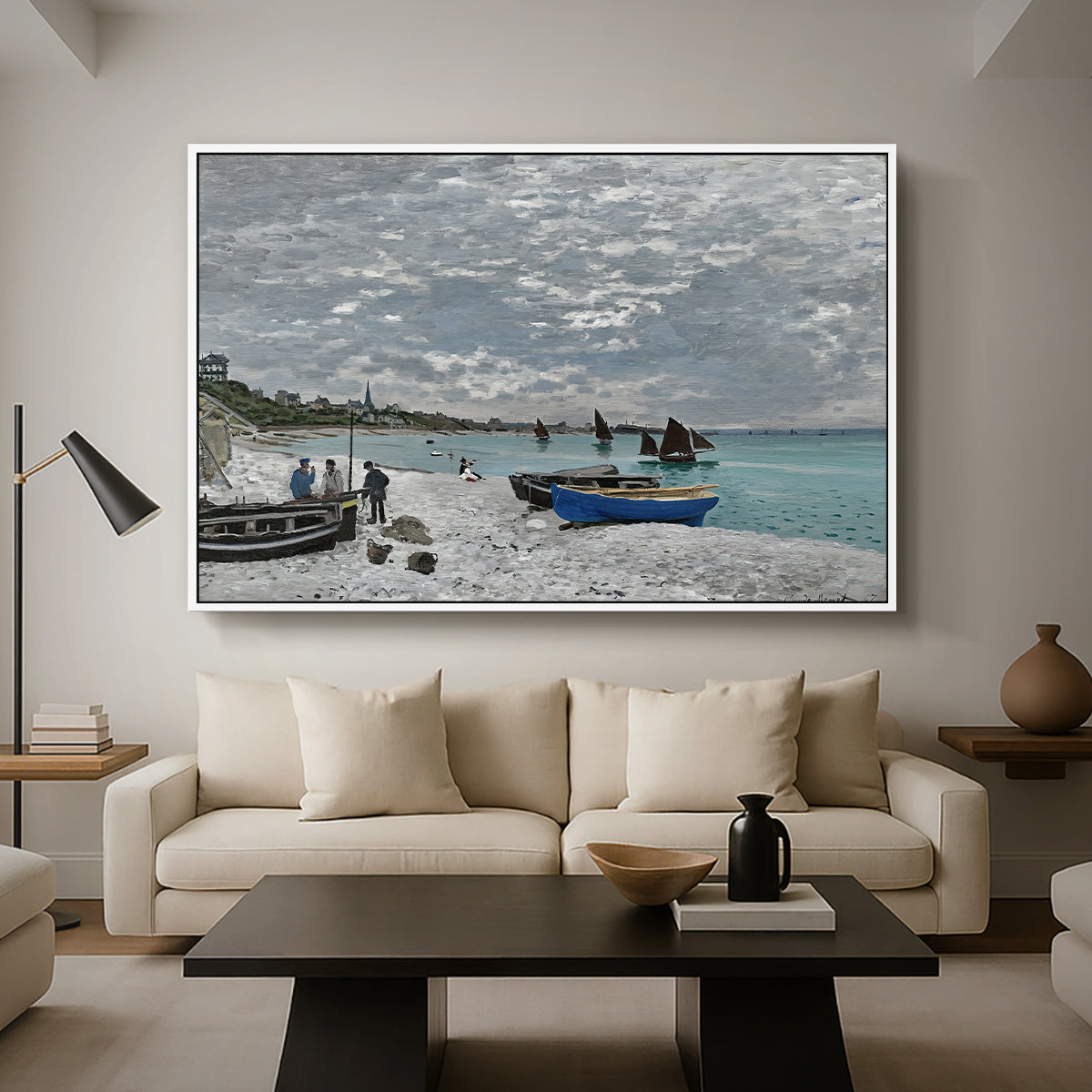 The Beach at Sainte-Adresse, 1867 by Claude Monet as a white floater framed canvas featuring a seaside promenade with figures, flags, and boats along the coast, displayed above a sofa in a modern living room.