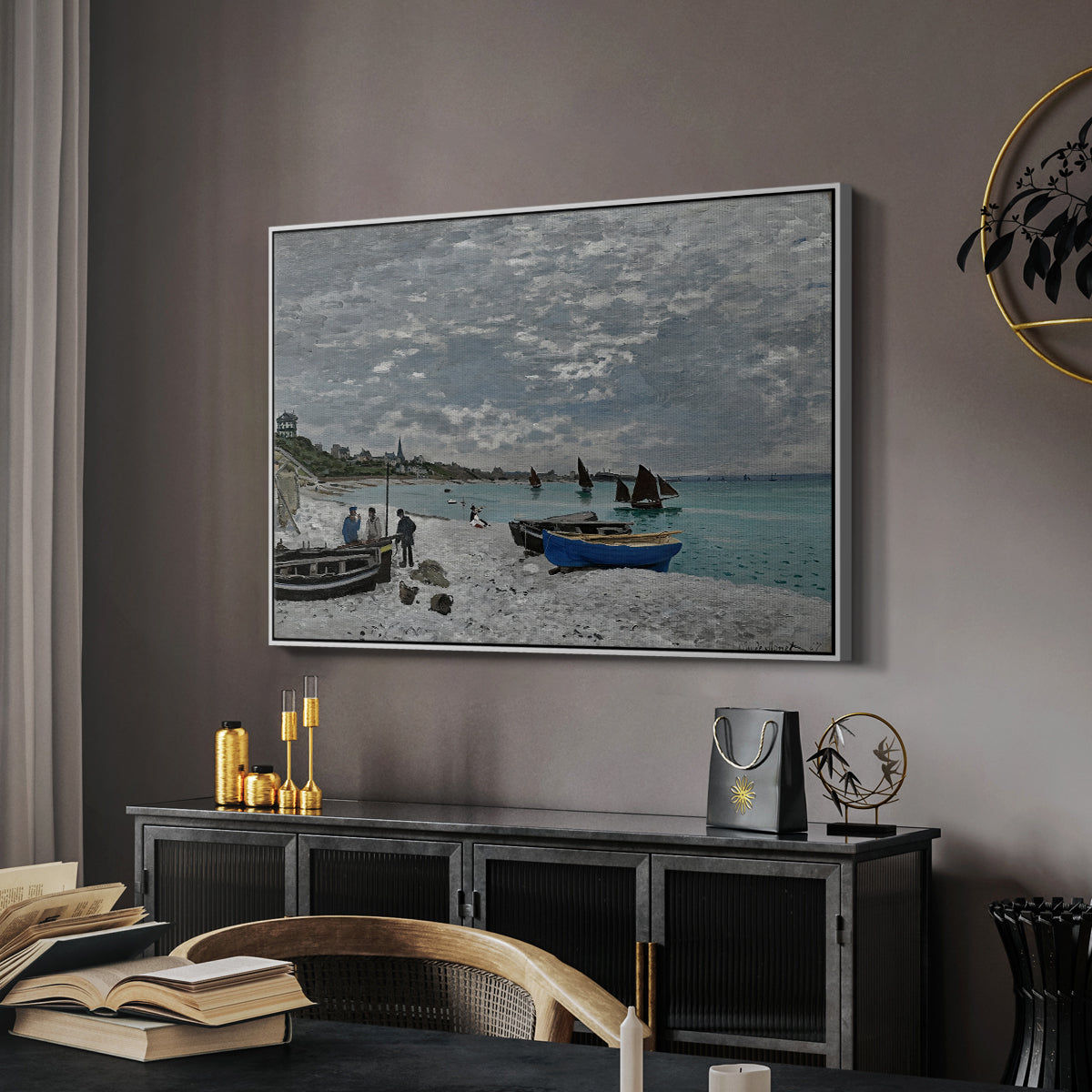 The Beach at Sainte-Adresse, 1867 by Claude Monet in a white floater framed canvas featuring a coastal landscape with sailboats and visitors on cliffside, displayed above a desk in a dark home office interior.