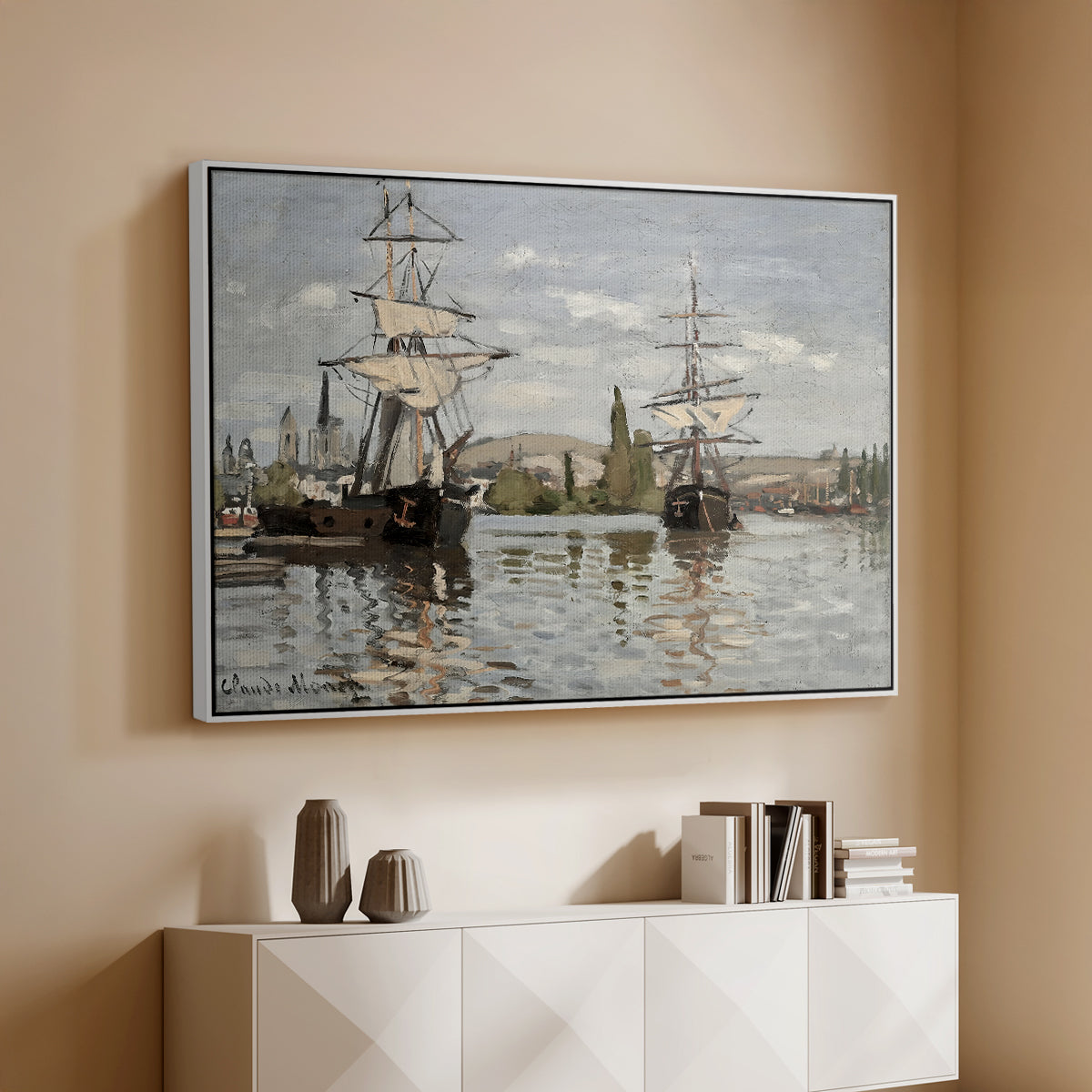 White floater framed canvas of Ships Riding on the Seine at Rouen, 1872 by Claude Monet, featuring an impressionist river scene with anchored sailing ships and reflections above a console cabinet in a minimalist entryway.