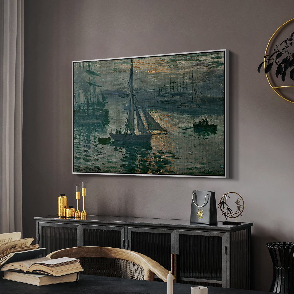 Sunrise (Marine), 1873 by Claude Monet in a white floater framed canvas featuring an early morning harbor scene with boats and diffused light, displayed above a desk in a dark home office interior.