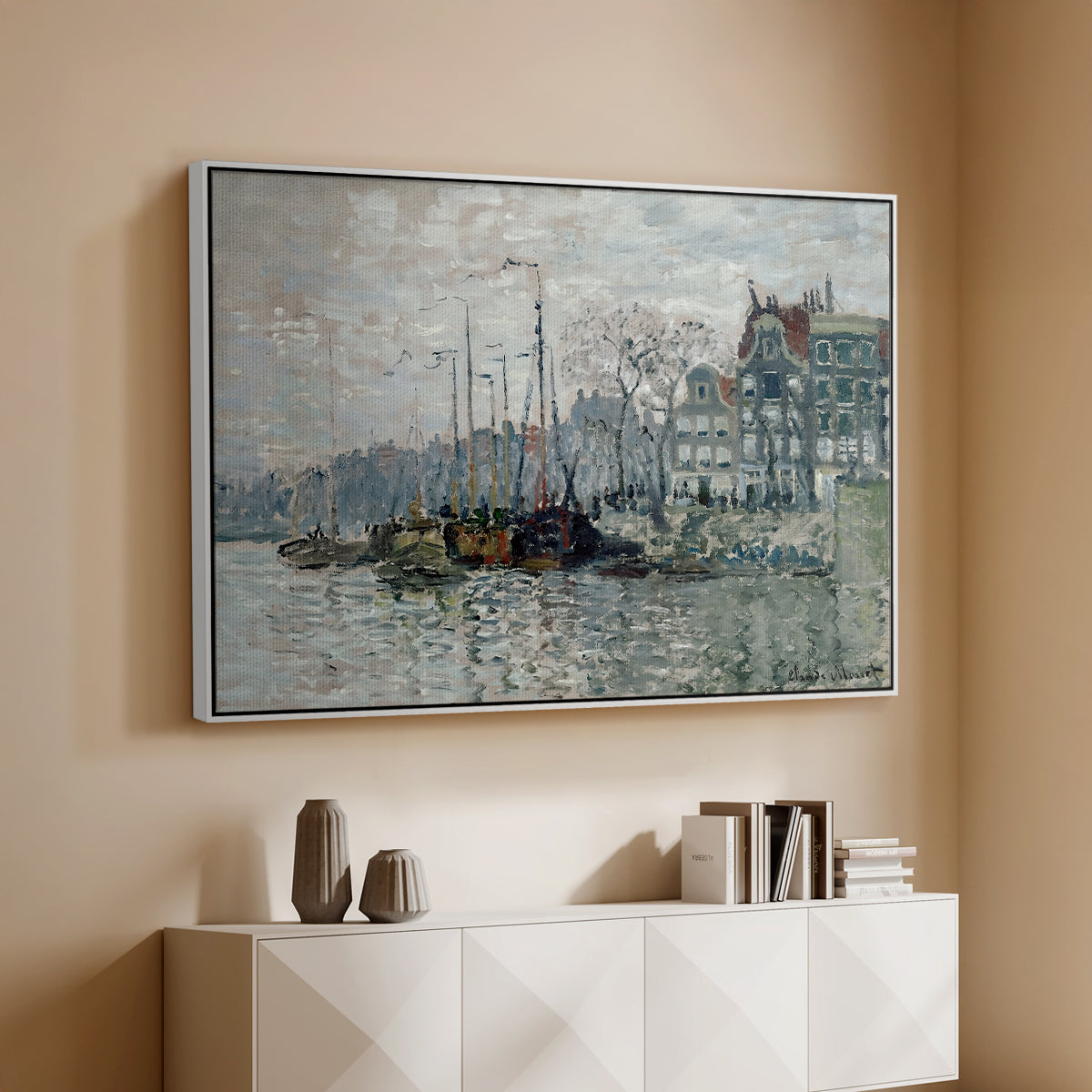 White floater framed canvas of View of the Prins Hendrikkade and Kromme Waal in Amsterdam, 1874 by Claude Monet, featuring an impressionist cityscape of canal with ships and architecture above a console cabinet in a minimalist entryway.