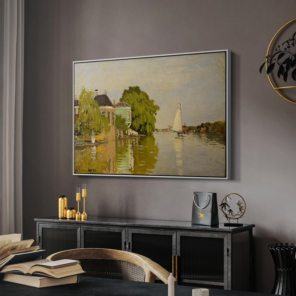 Houses on the Achterzaan, 1871 by Claude Monet in a white floater framed canvas featuring an impressionist landscape with buildings along quiet canal, displayed above a desk in a dark home office interior.