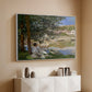 White floater framed canvas of On the Bank of the Seine, Bennecourt, 1868 by Claude Monet, featuring a peaceful riverside scene with figures resting in grassy area by water above a console cabinet in a minimalist entryway.