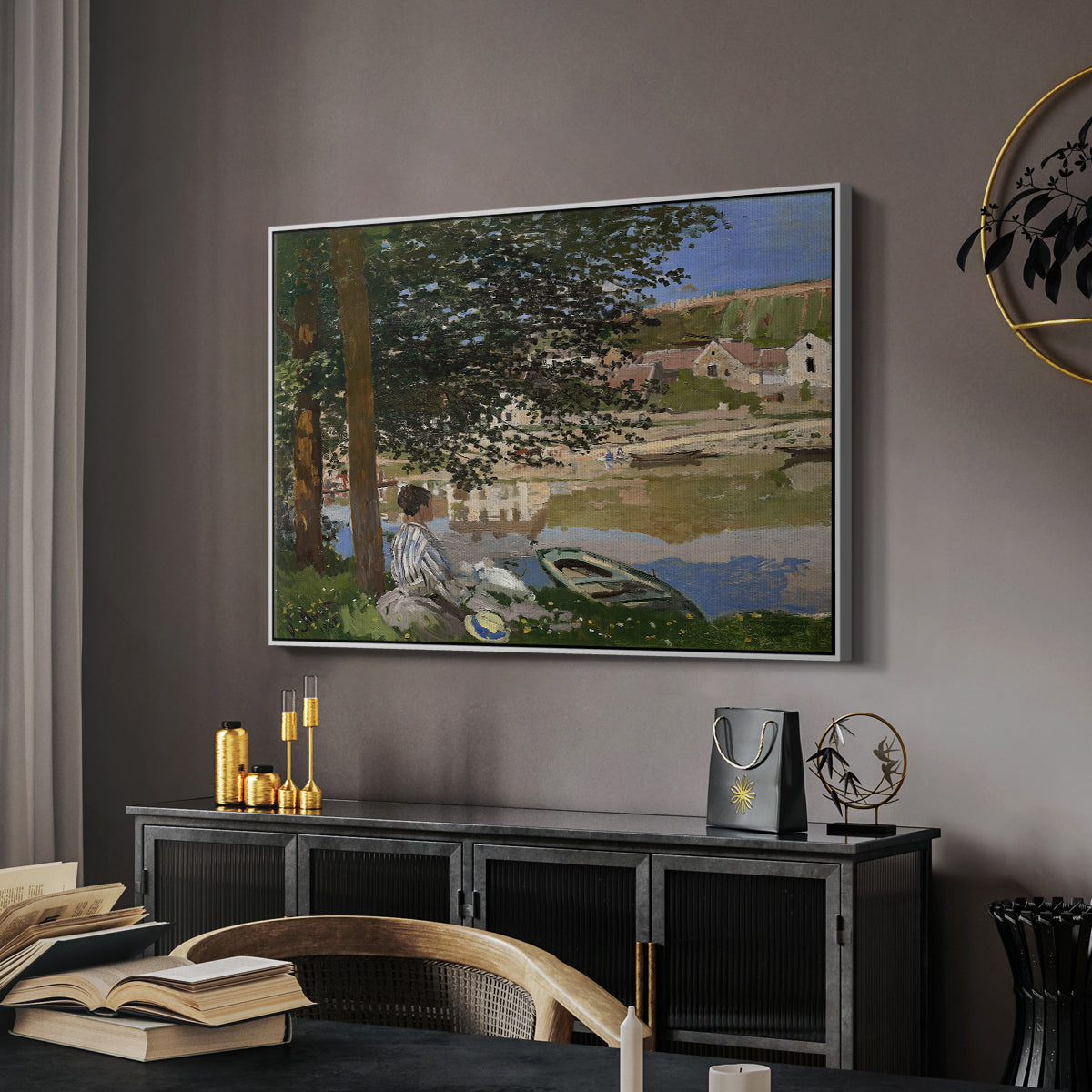 On the Bank of the Seine, Bennecourt, 1868 by Claude Monet in a white floater framed canvas featuring an impressionist landscape with people relaxing along the Seine, displayed above a desk in a dark home office interior.