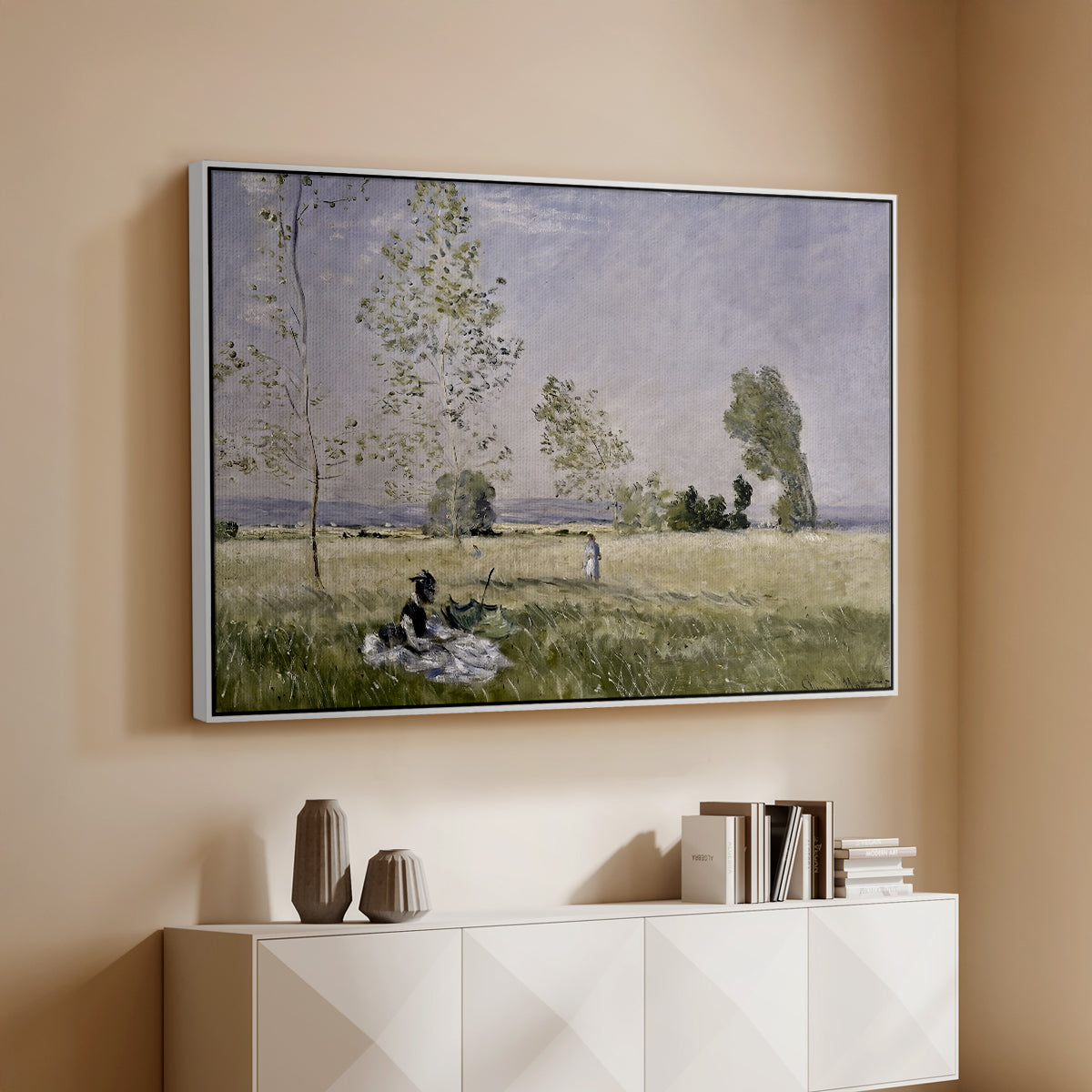 White floater framed canvas of Summer (L'ete), 1874 by Claude Monet, featuring an impressionist countryside scene with figure resting in shade above a console cabinet in a minimalist entryway.