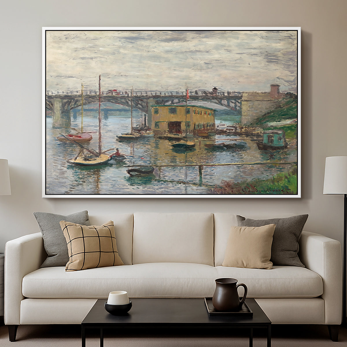 Bridge at Argenteuil on a Gray Day, c. 1876 by Claude Monet displayed in a white floater framed canvas above a sofa in a clean living room.