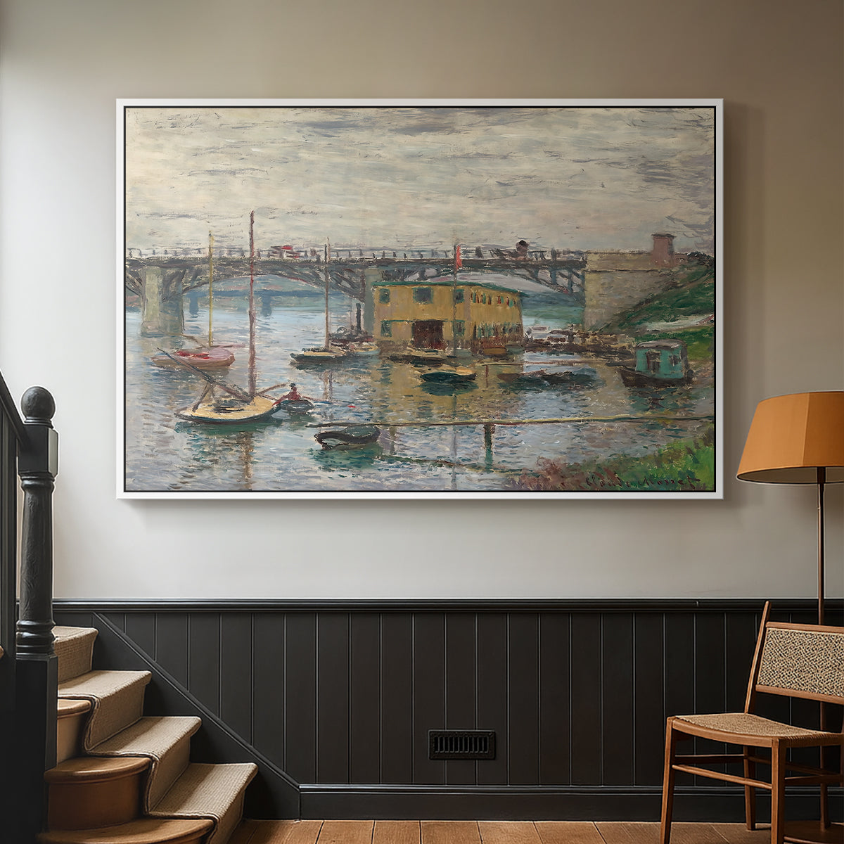 White floater framed canvas featuring a subdued urban landscape with structure spanning river, displayed in a hallway near a staircase.