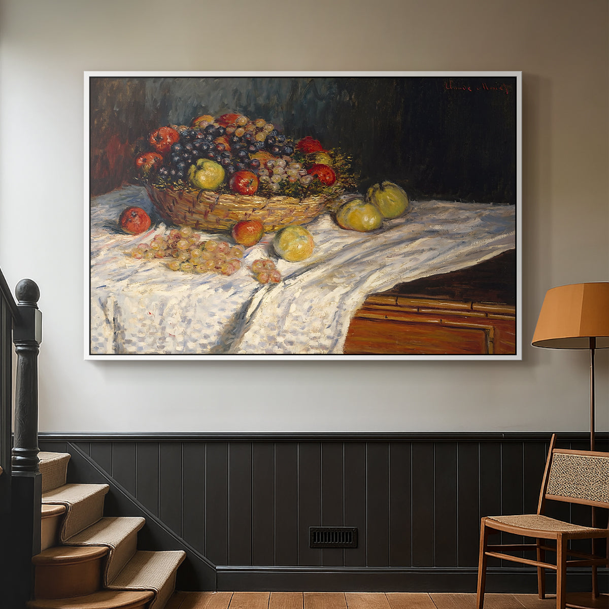 White floater framed canvas featuring a tabletop composition with fruit and subtle shadows, displayed in a hallway near a staircase.