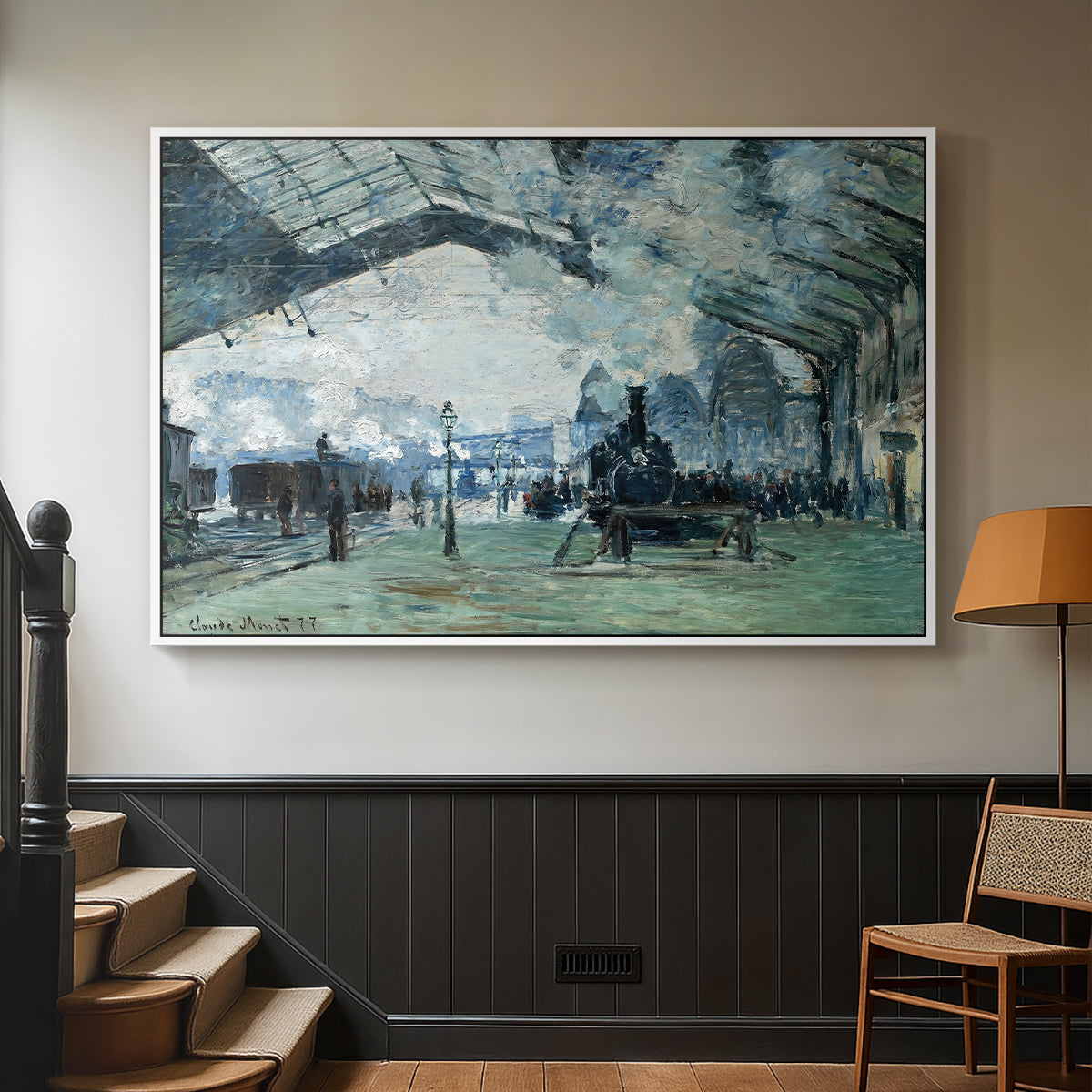 White floater framed canvas featuring a dramatic depiction of industrial space with trains and light, displayed in a hallway near a staircase.