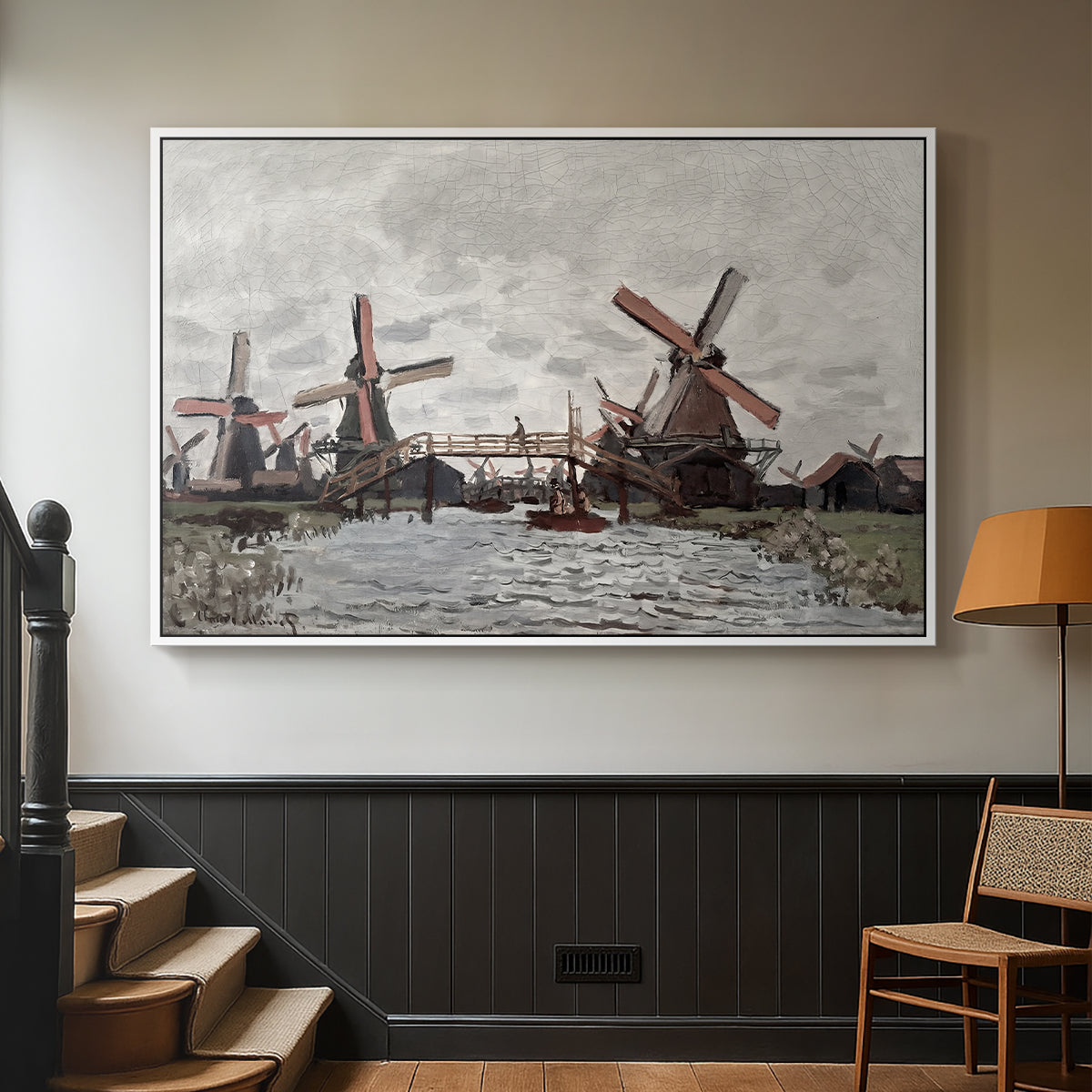 White floater framed canvas featuring a landscape featuring windmills and low horizon sky, displayed in a hallway near a staircase.