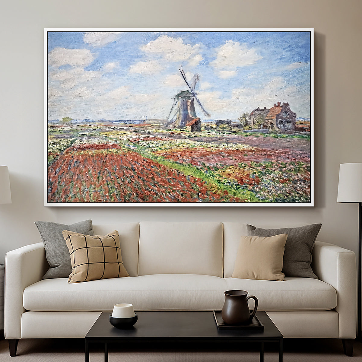 Tulip Fields with the Rijnsburg Windmill, 1886 by Claude Monet displayed in a white floater framed canvas above a sofa in a clean living room.