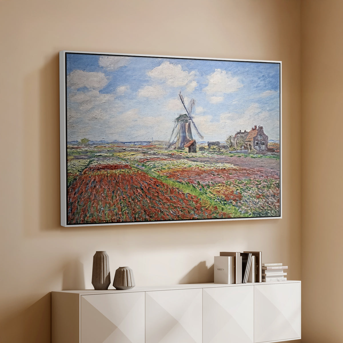 White floater framed canvas of Tulip Fields with the Rijnsburg Windmill, 1886 by Claude Monet, featuring a vibrant agricultural landscape with flowers and windmill above a console cabinet in a minimalist entryway.