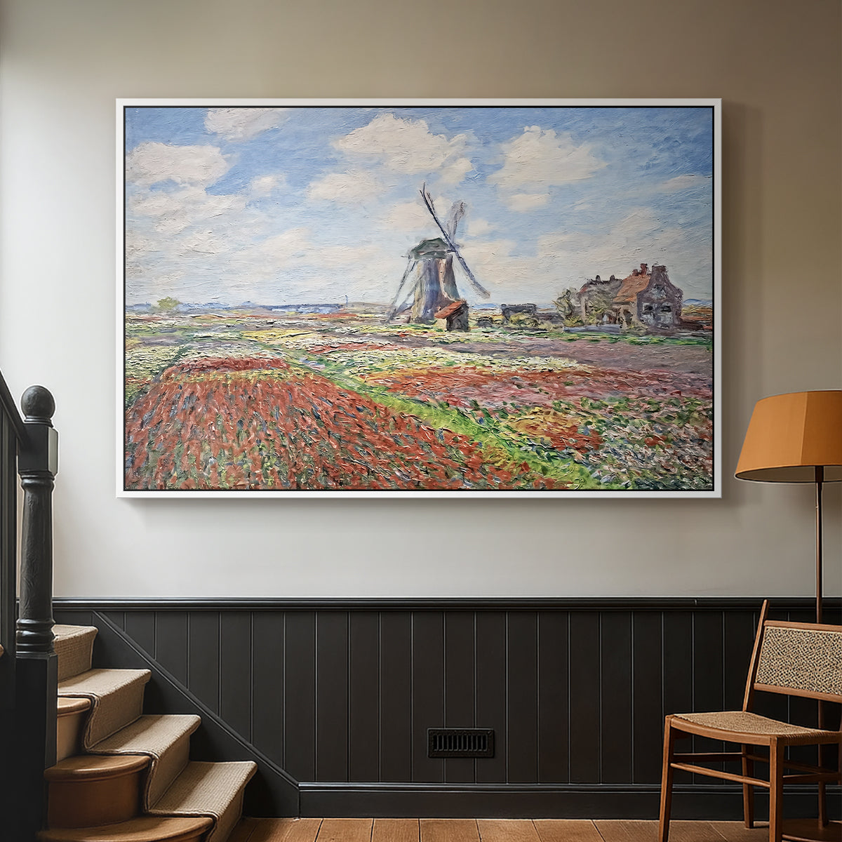 White floater framed canvas featuring a rural scene with patterned rows of flowers and windmill, displayed in a hallway near a staircase.