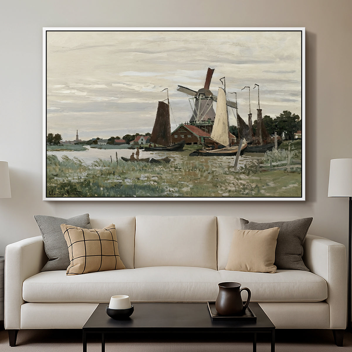 Windmill at Zaandam, 1871 by Claude Monet displayed in a white floater framed canvas above a sofa in a clean living room.