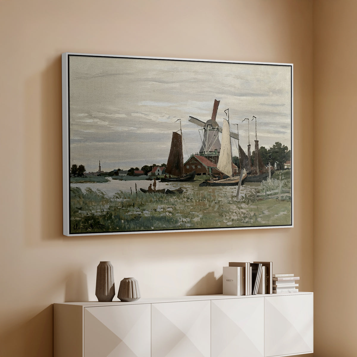 White floater framed canvas of Windmill at Zaandam, 1871 by Claude Monet, featuring an impressionist depiction of windmill near riverbank above a console cabinet in a minimalist entryway.