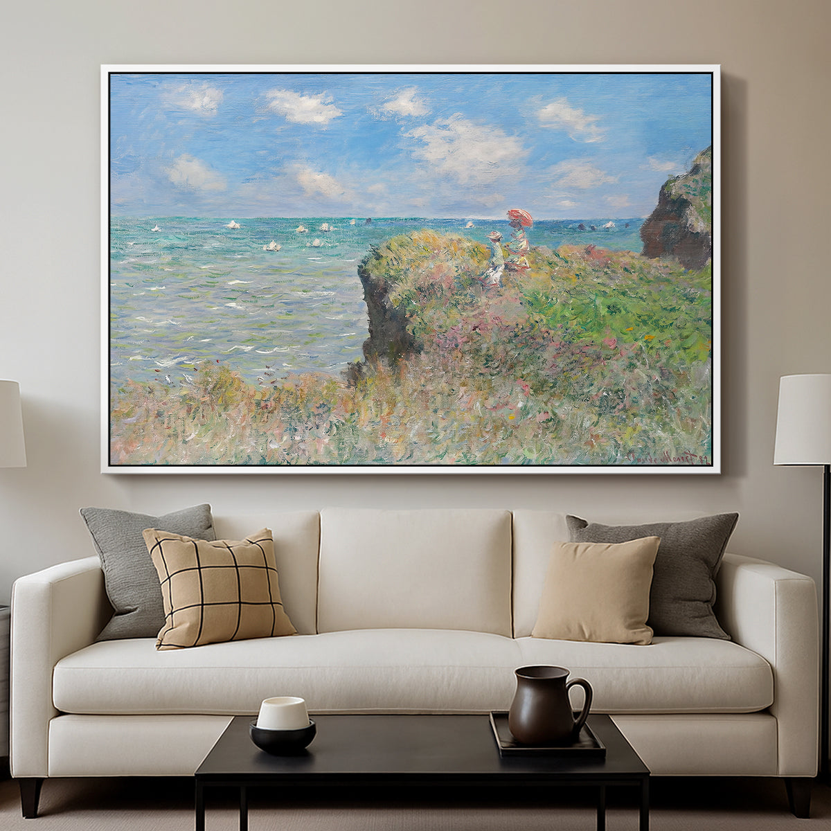 The Cliff Walk at Pourville, 1882 by Claude Monet displayed in a white floater framed canvas above a sofa in a clean living room.