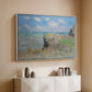 White floater framed canvas of The Cliff Walk at Pourville, 1882 by Claude Monet, featuring an impressionist seaside landscape with people strolling above water above a console cabinet in a minimalist entryway.