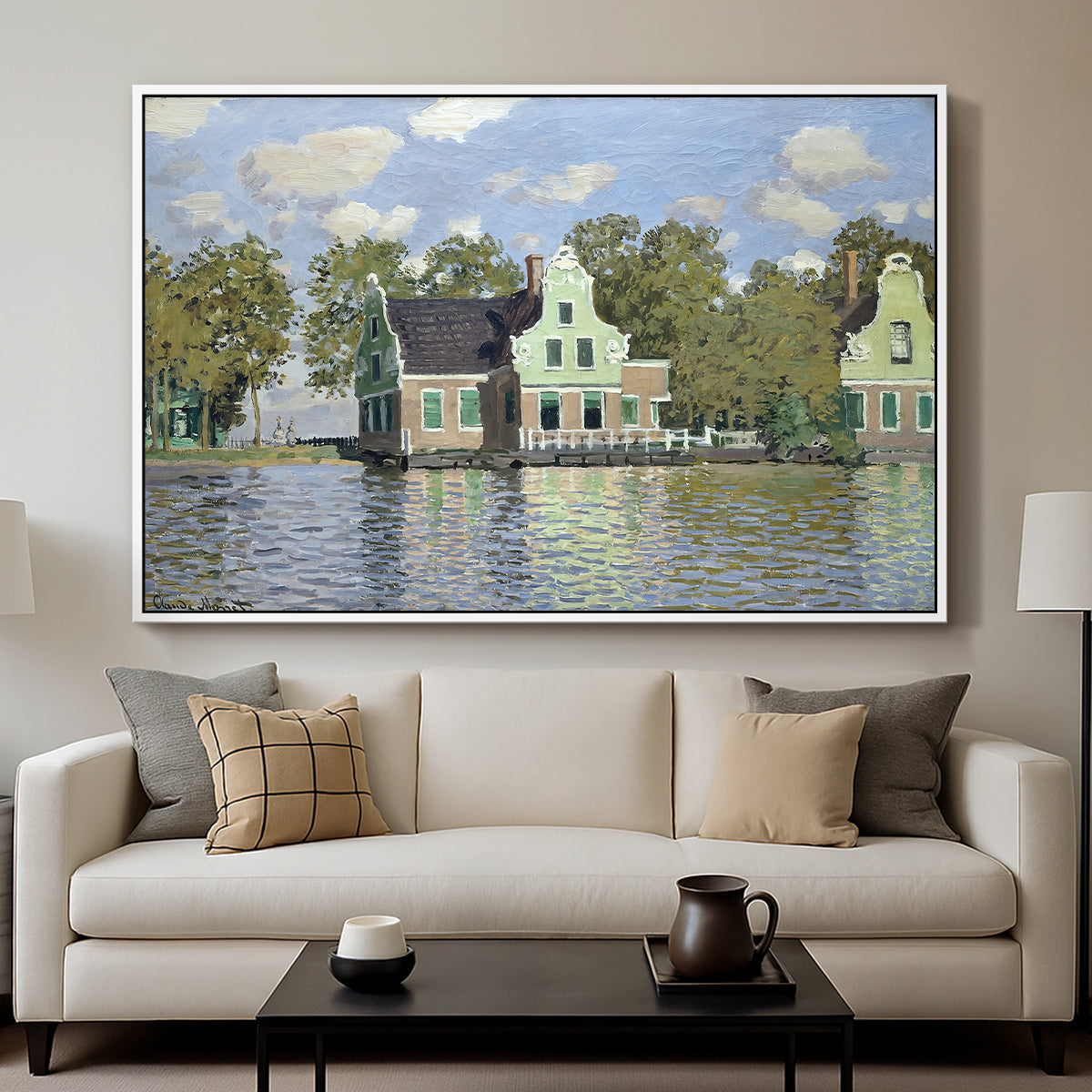 Houses on the Zaan River at Zaandam, 1871 by Claude Monet displayed in a white floater framed canvas above a sofa in a clean living room.