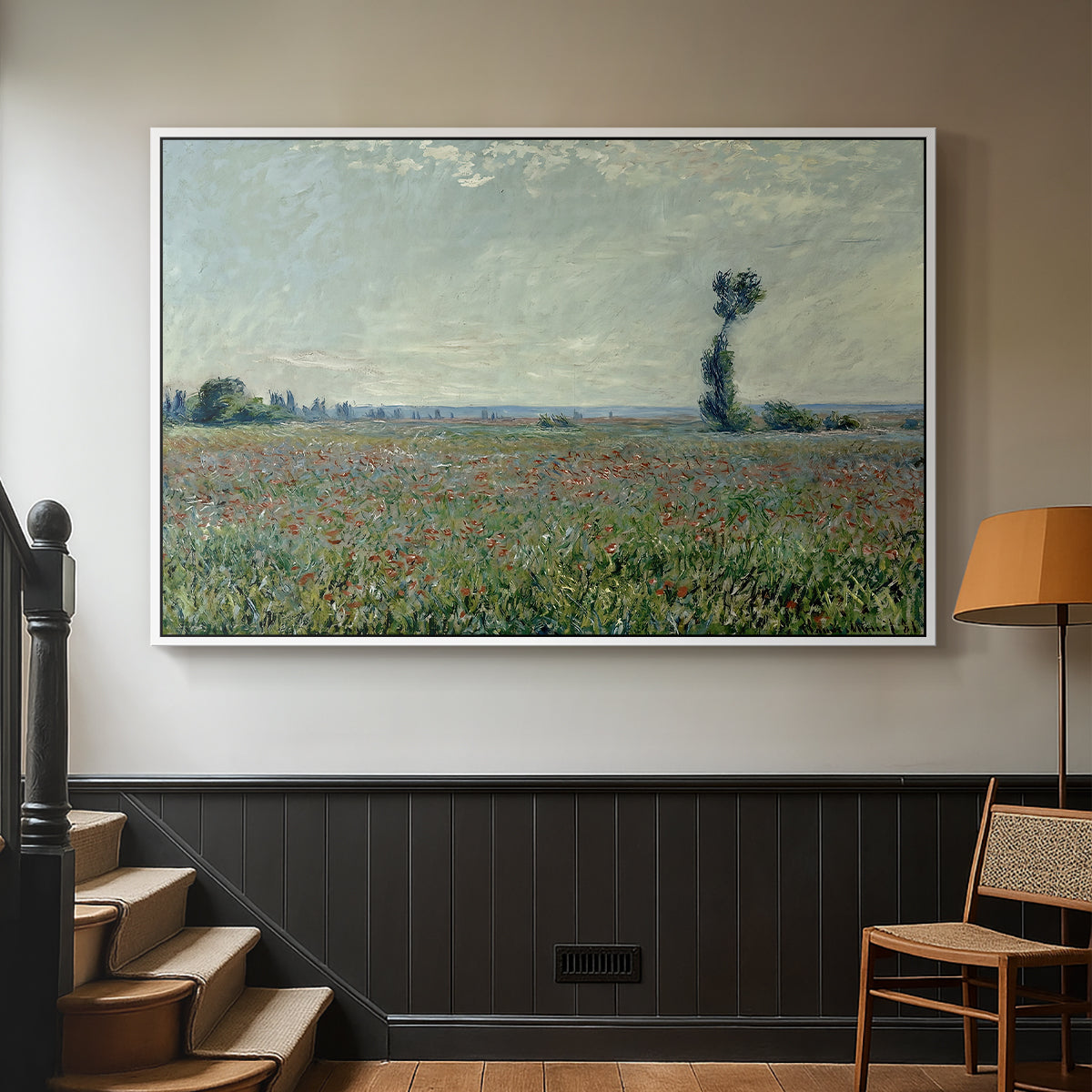 White floater framed canvas featuring a natural field scene with vibrant red flowers, displayed in a hallway near a staircase.