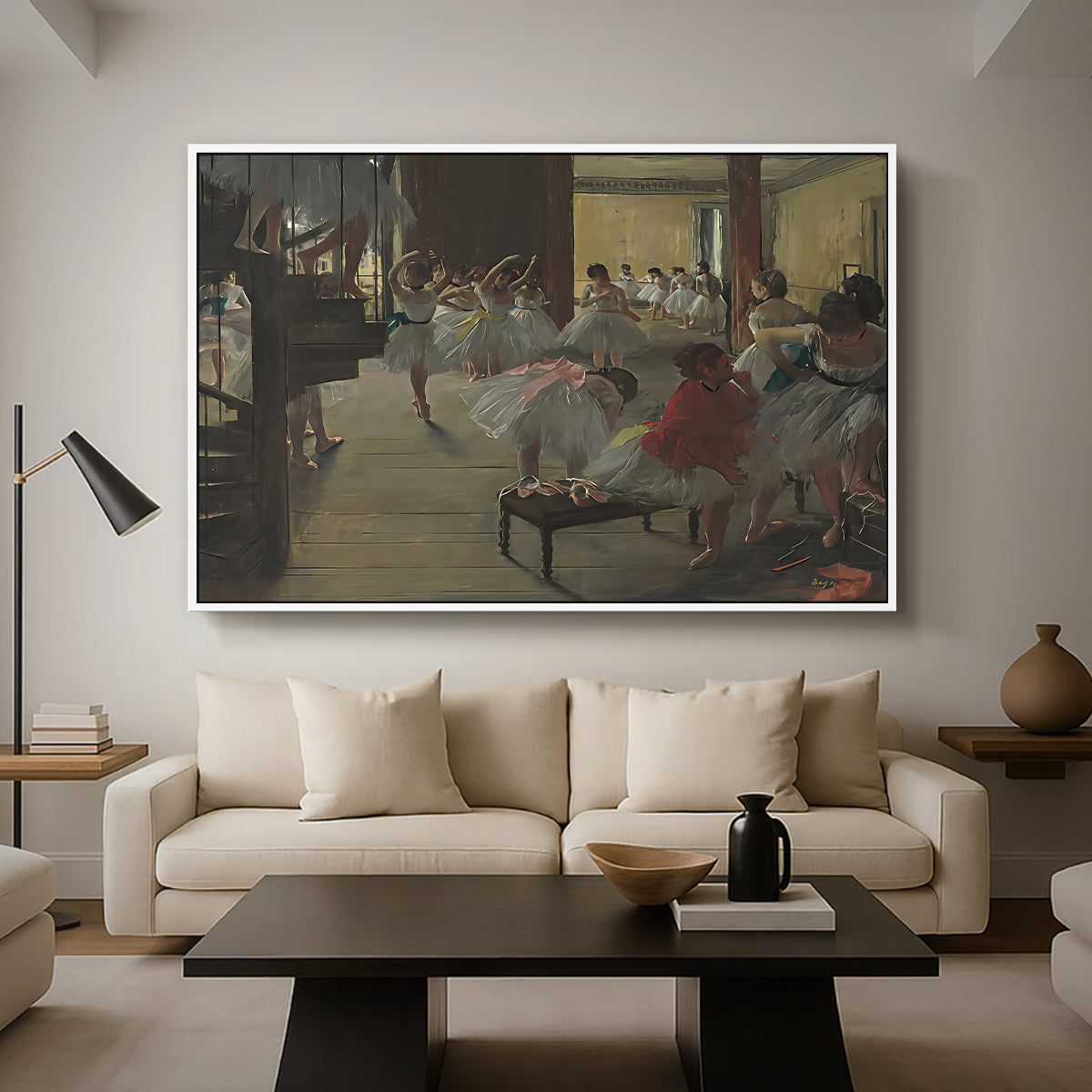 The Dance Class, c. 1873 by Edgar Degas as a white floater framed canvas featuring ballerinas practicing in studio with instructor observing nearby, displayed above a sofa in a modern living room.