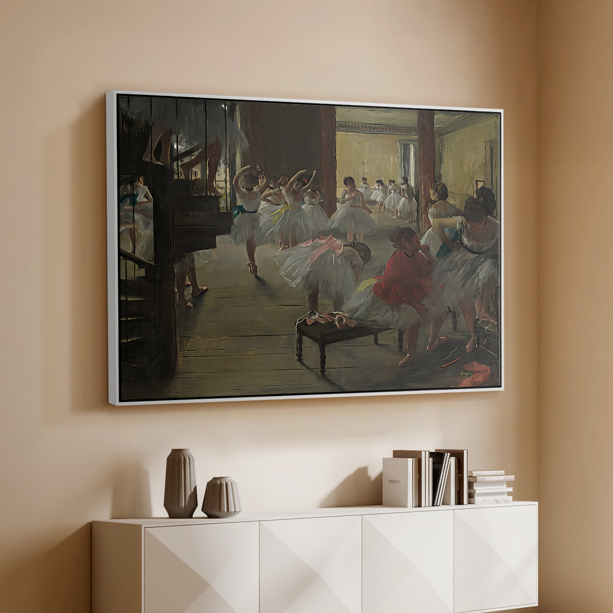 White floater framed canvas of The Dance Class, c. 1873 by Edgar Degas, featuring a rehearsal scene with dancers stretching and posing indoors above a console cabinet in a minimalist entryway.