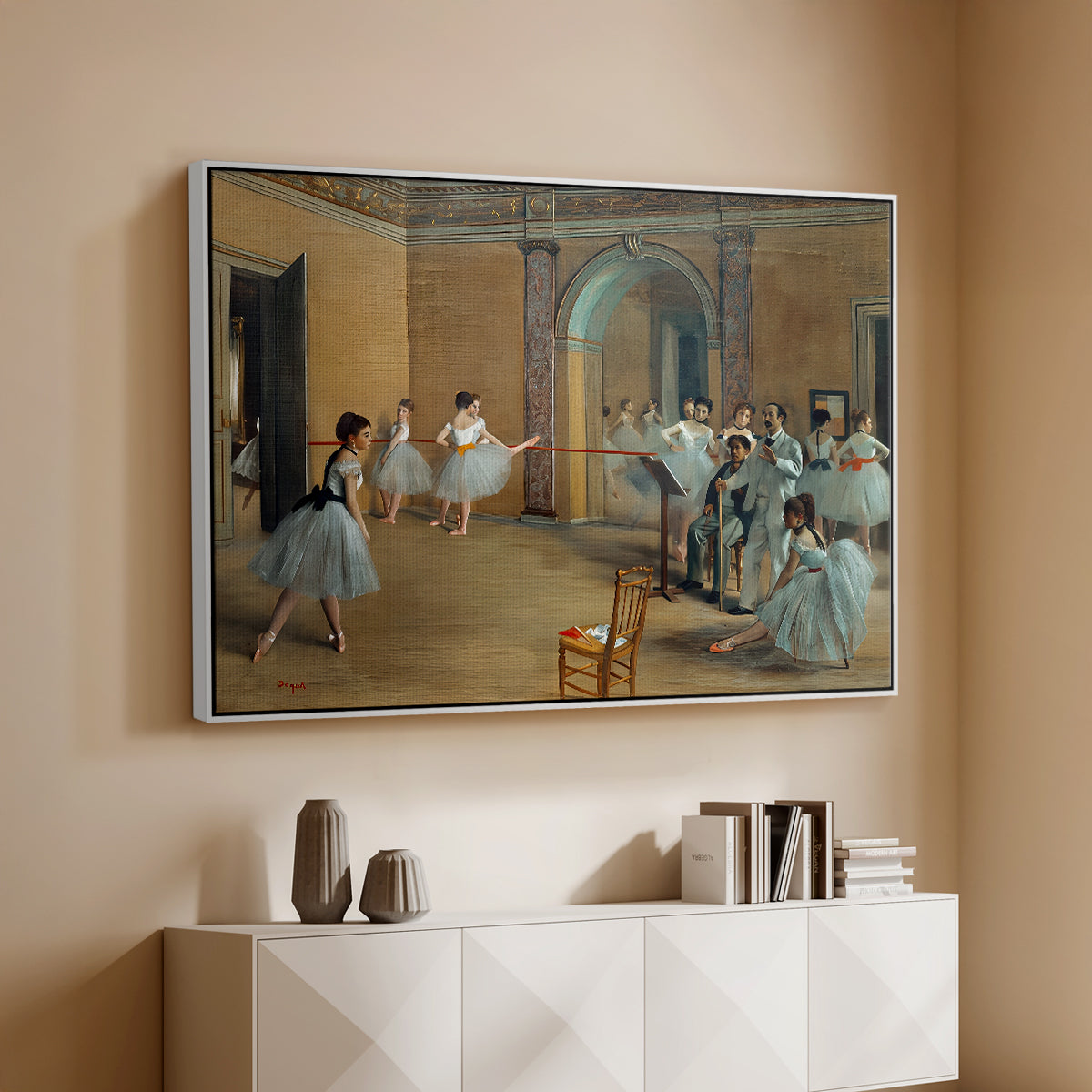 White floater framed canvas of The Dance Foyer at the Opera on the Rue Le Peletier, 1872 by Edgar Degas, featuring an interior scene of dancers waiting and stretching in large studio above a console cabinet in a minimalist entryway.