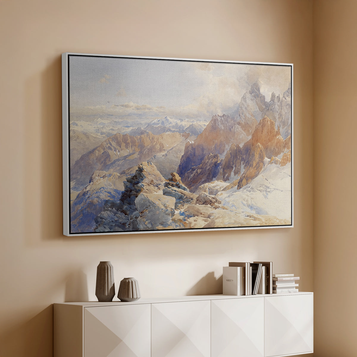 White floater framed canvas of Col du Géant, 1903 by Edward Theodore Compton, featuring a high mountain landscape featuring dramatic ridges and glacier terrain above a console cabinet in a minimalist entryway.