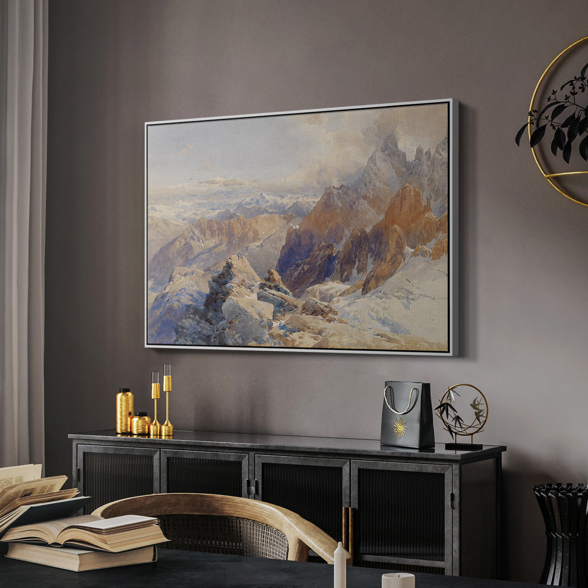 Col du Géant, 1903 by Edward Theodore Compton in a white floater framed canvas featuring a panoramic alpine view with snow and rocky cliffs, displayed above a desk in a dark home office interior.