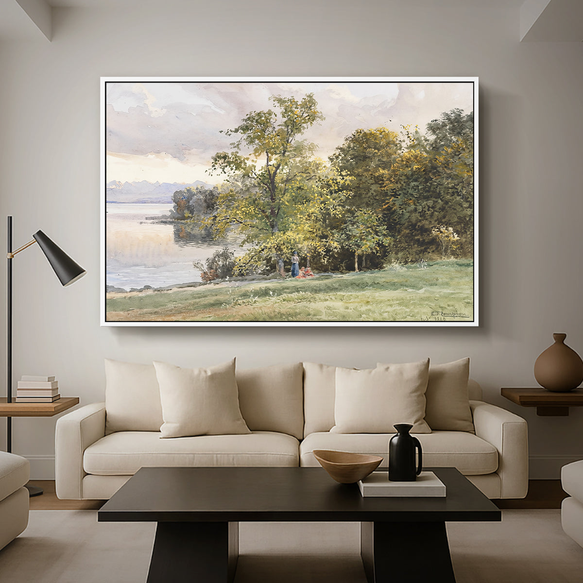 Landscape at Lake Starnberg, 1890 by Edward Theodore Compton as a white floater framed canvas featuring a lakeside landscape with calm water and trees along shoreline, displayed above a sofa in a modern living room.